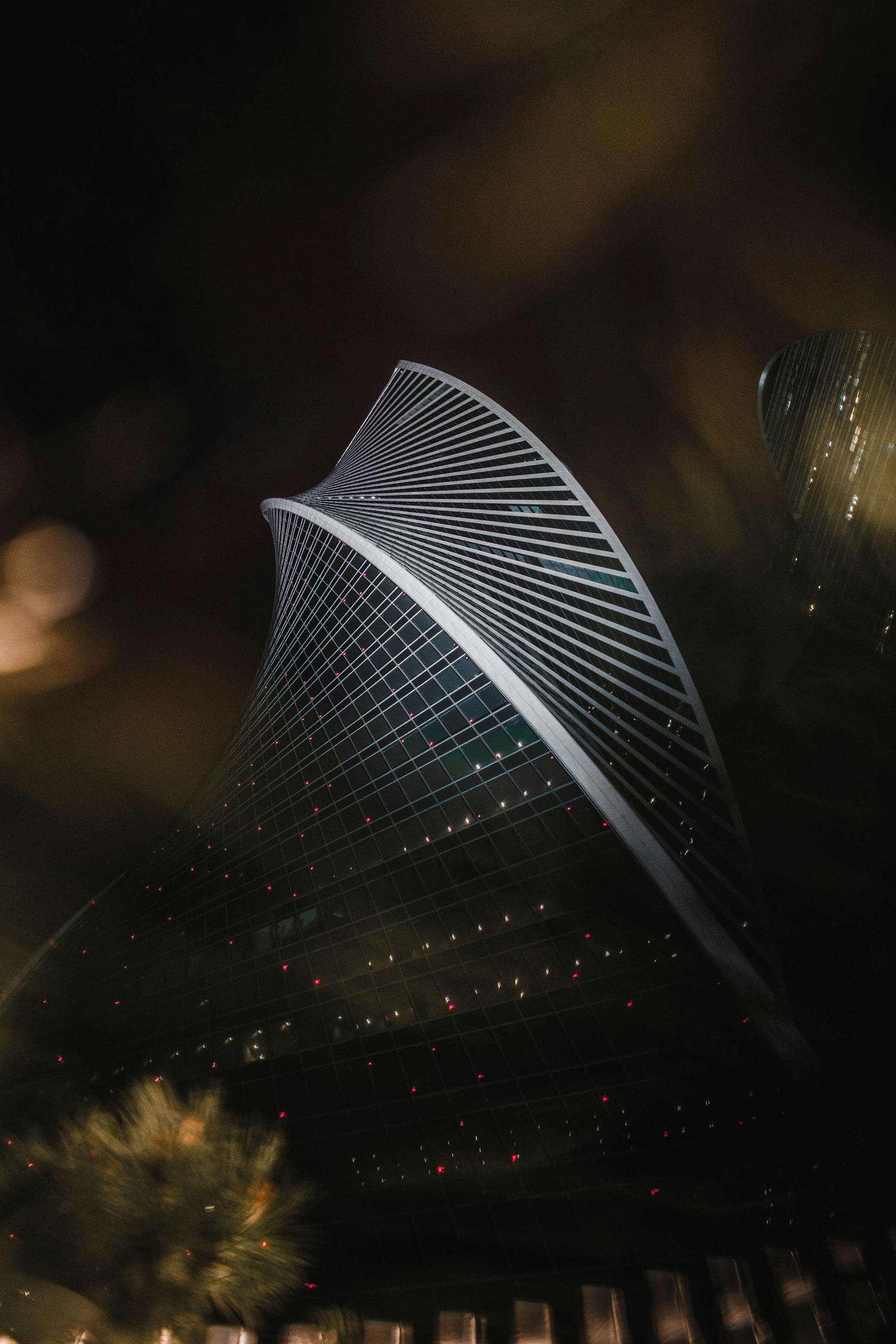 Stunning night view of the architectural marvel Majdoul Tower in Riyadh, showcasing its unique twisting design.